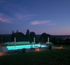 Illuminated pool at night, overlooking twinkling valley lights